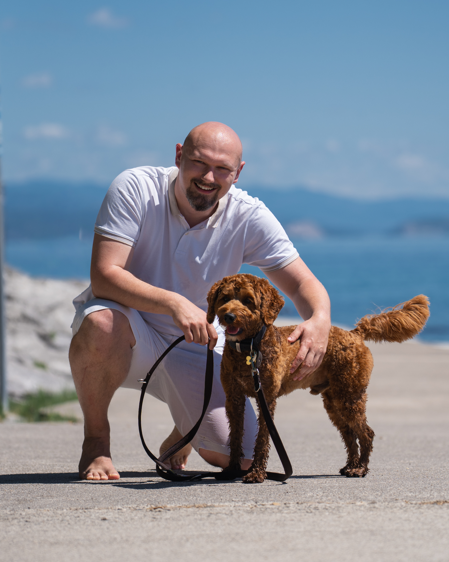 Marvin mit Smoki, einem rotbraunen Labradoodle, an der kroatischen Küste